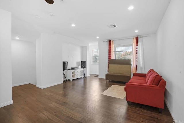 living room featuring dark hardwood / wood-style floors and ceiling fan