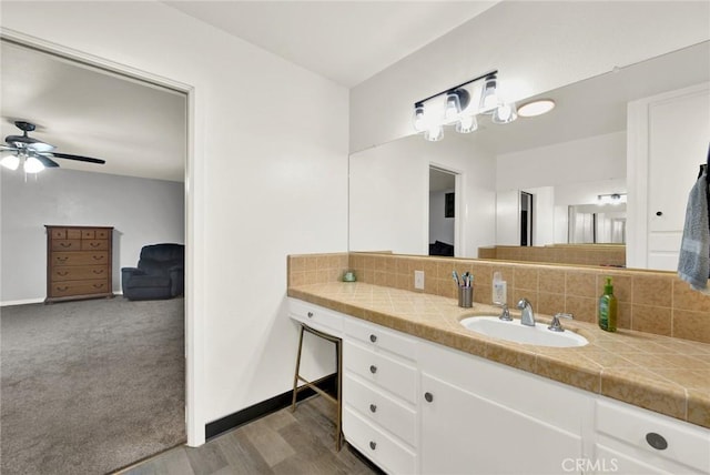 bathroom featuring backsplash, ceiling fan, vanity, and hardwood / wood-style flooring