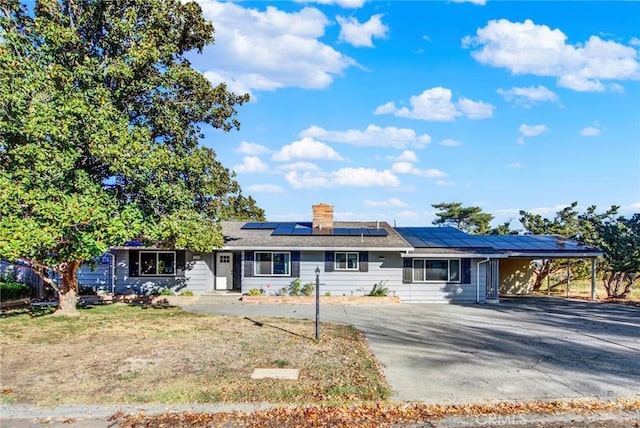 1938 Colusa, Corning, CA 96021 - ranch-style house featuring asphalt driveway, a carport, roof mounted solar panels, a chimney, and a front yard