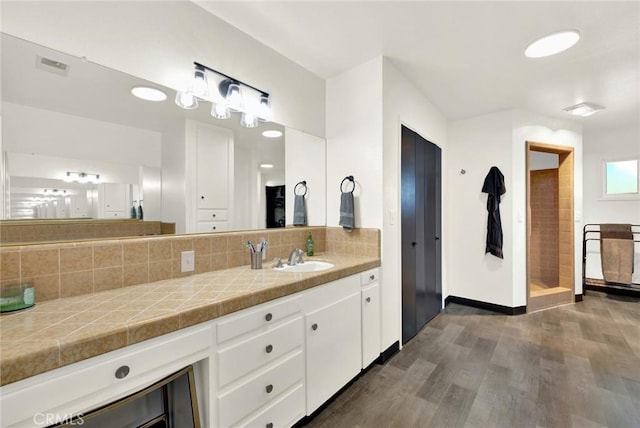 bathroom with hardwood / wood-style flooring, vanity, and tasteful backsplash