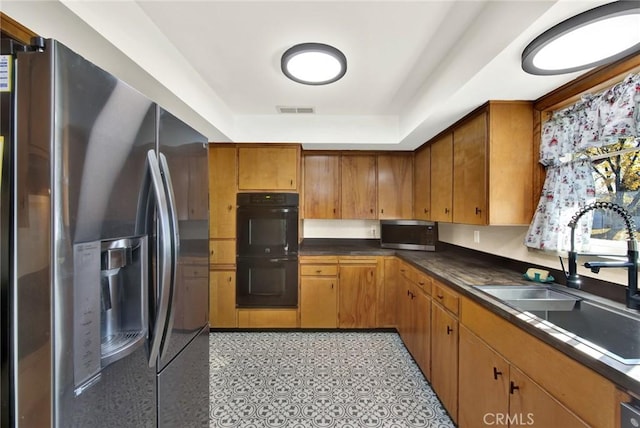 1938 Colusa, Corning, CA 96021 - kitchen featuring stainless steel appliances, brown cabinets, dark countertops, and a tray ceiling