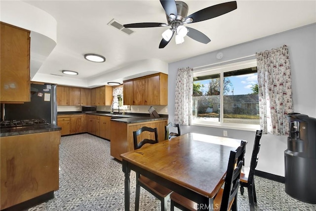 kitchen with black fridge, ceiling fan, and sink