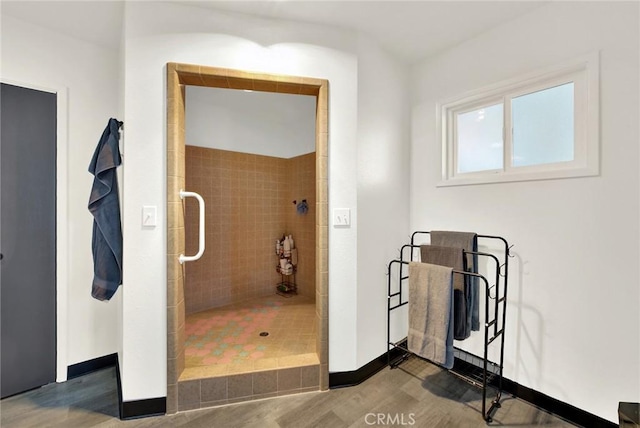 bathroom with hardwood / wood-style floors and a tile shower