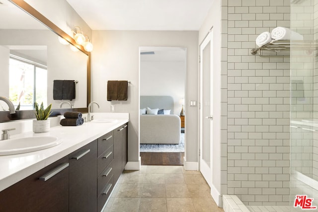 bathroom featuring hardwood / wood-style flooring, vanity, and tiled shower