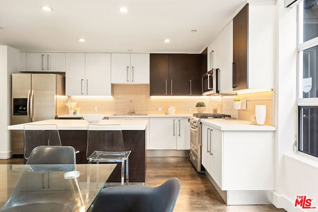 kitchen with decorative backsplash, stainless steel appliances, dark wood-type flooring, sink, and a kitchen island