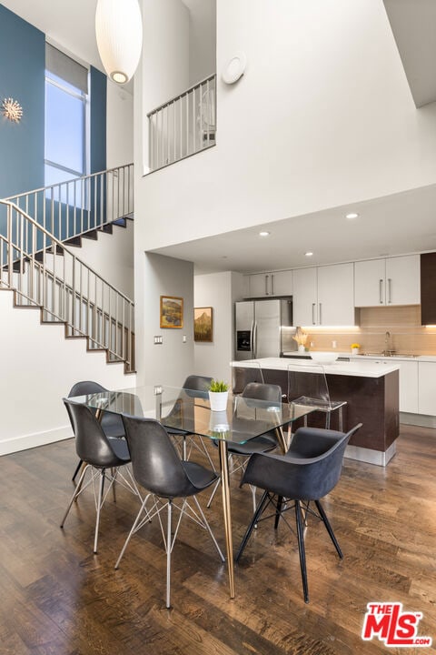 dining room with a high ceiling and dark hardwood / wood-style floors