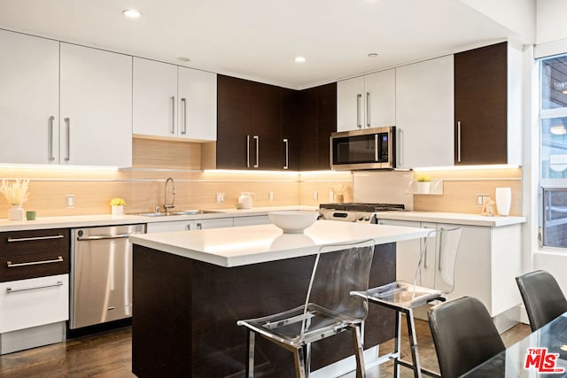 kitchen featuring a kitchen breakfast bar, dark hardwood / wood-style flooring, dark brown cabinetry, and stainless steel appliances