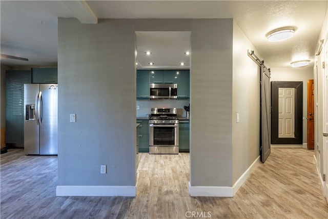 corridor featuring light hardwood / wood-style flooring and a barn door