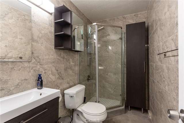 bathroom with toilet, a textured ceiling, an enclosed shower, tile walls, and vanity