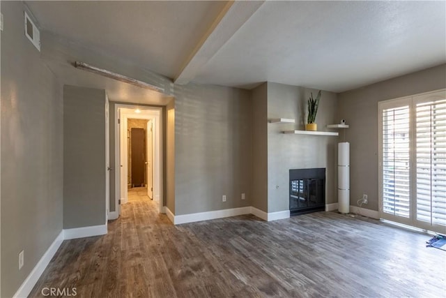 unfurnished living room with wood-type flooring and beam ceiling