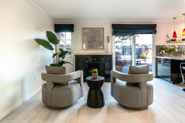 sitting room with a fireplace, hardwood / wood-style floors, bar, and ornamental molding