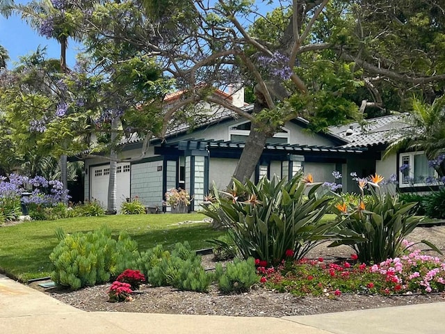 view of front of property featuring a garage and a front lawn