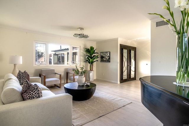 living room featuring crown molding and light hardwood / wood-style flooring