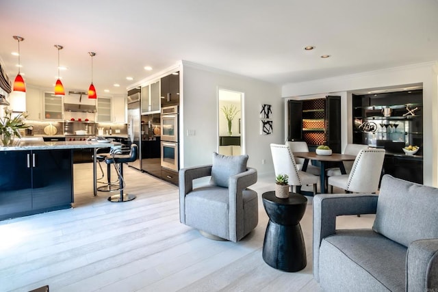 living room with light hardwood / wood-style floors, ornamental molding, and sink