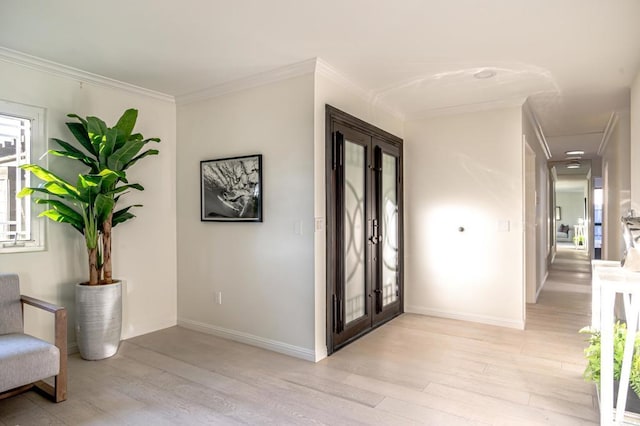 entrance foyer with crown molding, light hardwood / wood-style flooring, and french doors