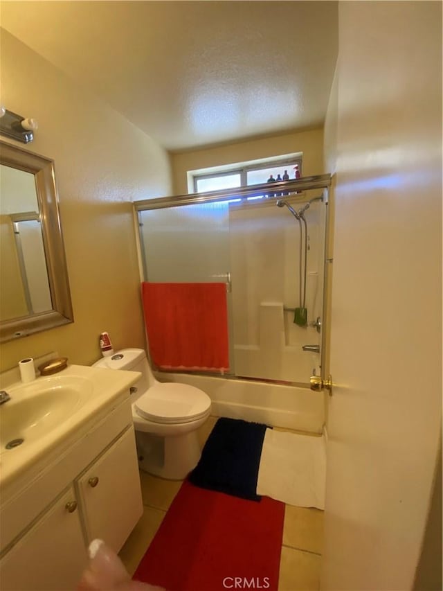 full bathroom with toilet, vanity, tile patterned floors, and enclosed tub / shower combo