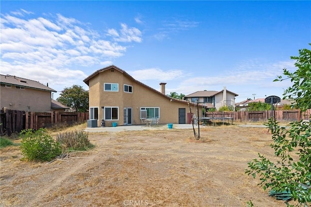 back of house with a patio area, cooling unit, and a trampoline