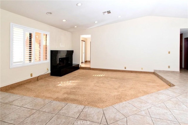 unfurnished living room featuring light colored carpet and vaulted ceiling