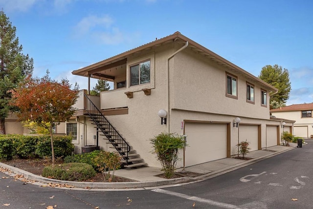 view of side of property featuring a garage and central air condition unit