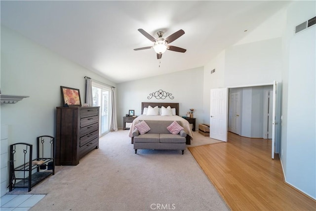 bedroom with ceiling fan, light hardwood / wood-style floors, and vaulted ceiling