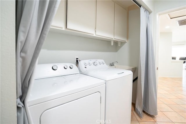 laundry area featuring sink, independent washer and dryer, light tile patterned flooring, and cabinets