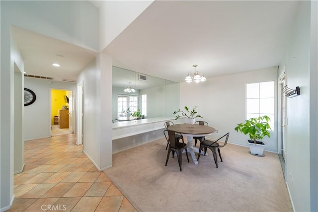 dining area featuring light colored carpet and a chandelier