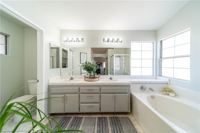 full bathroom with toilet, independent shower and bath, tile patterned floors, and vanity