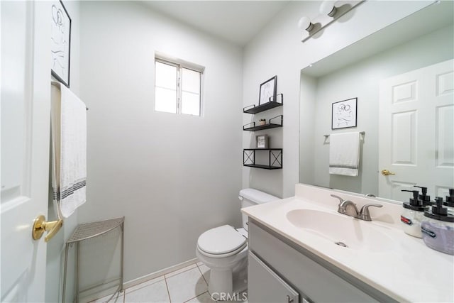 bathroom with toilet, vanity, and tile patterned flooring