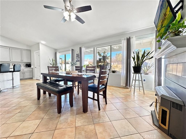 dining space featuring ceiling fan, light tile patterned floors, vaulted ceiling, and plenty of natural light