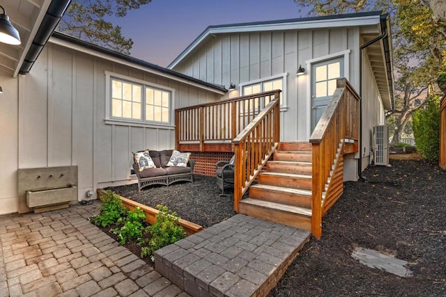 back house at dusk featuring an outdoor living space and a deck