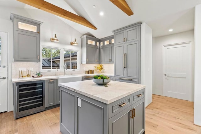 kitchen featuring decorative backsplash, sink, beverage cooler, and lofted ceiling with beams