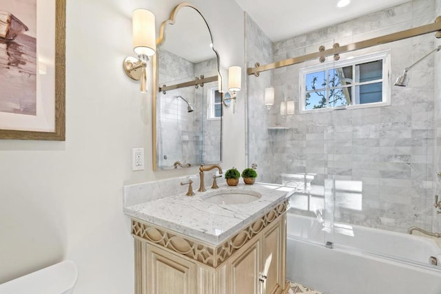 bathroom featuring combined bath / shower with glass door and vanity