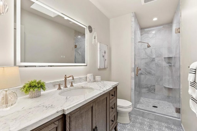 bathroom featuring walk in shower, vanity, tile patterned flooring, and toilet