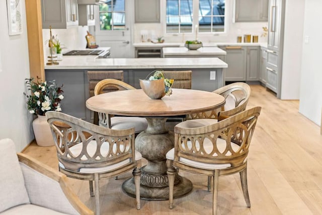 kitchen featuring gray cabinetry, light hardwood / wood-style flooring, kitchen peninsula, and backsplash