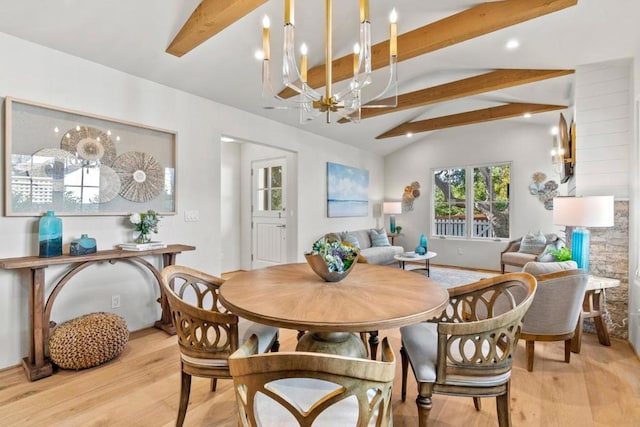 dining space featuring light hardwood / wood-style floors, vaulted ceiling with beams, and a notable chandelier