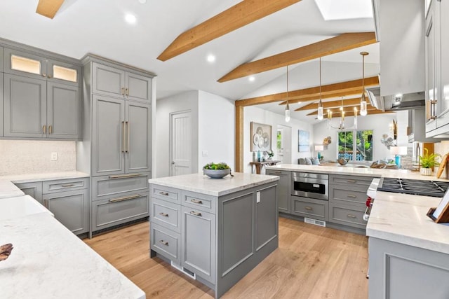 kitchen featuring gray cabinets, lofted ceiling with beams, and decorative light fixtures