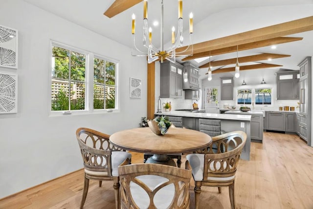 dining room with vaulted ceiling with beams, a chandelier, and light hardwood / wood-style flooring