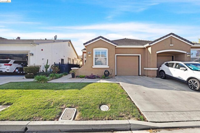 single story home with a garage and a front lawn