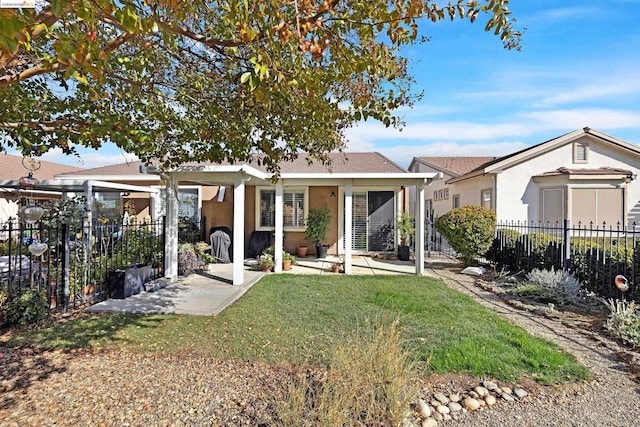 rear view of house with a lawn and a patio