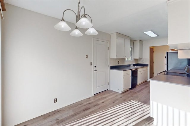 kitchen with pendant lighting, light hardwood / wood-style floors, white cabinets, and black dishwasher