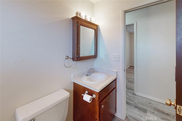 bathroom with hardwood / wood-style floors, vanity, and toilet