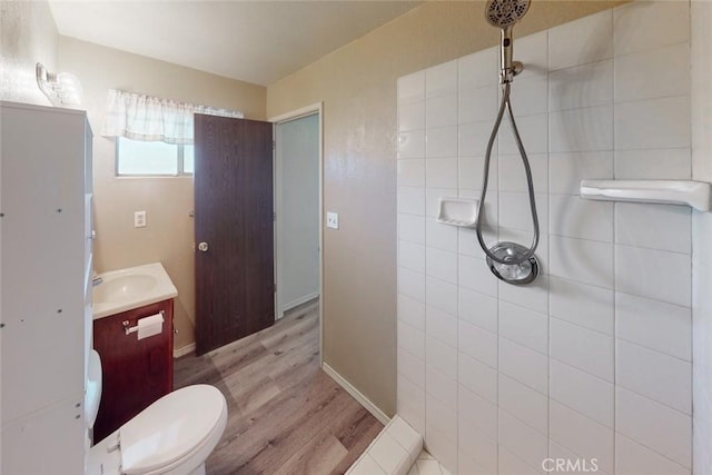 bathroom featuring a shower, hardwood / wood-style floors, vanity, and toilet