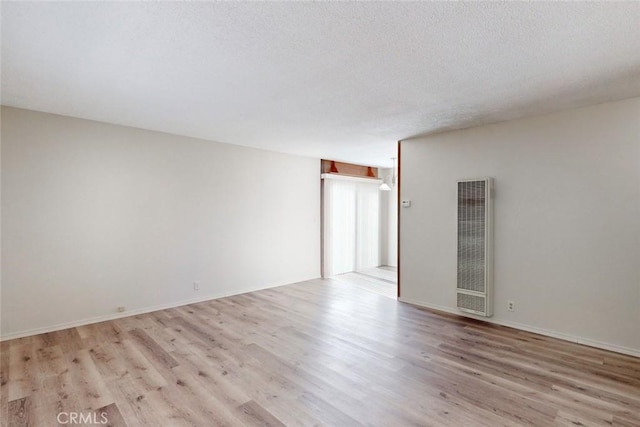 spare room featuring light hardwood / wood-style flooring and a textured ceiling