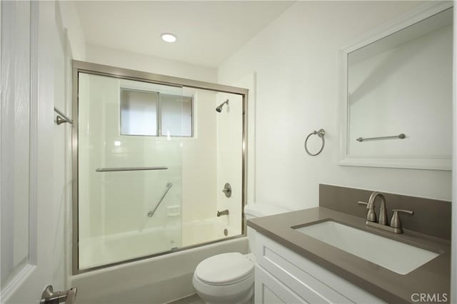 full bathroom featuring toilet, combined bath / shower with glass door, and vanity