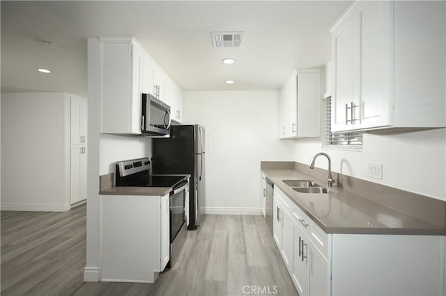 kitchen featuring white cabinetry, sink, and appliances with stainless steel finishes