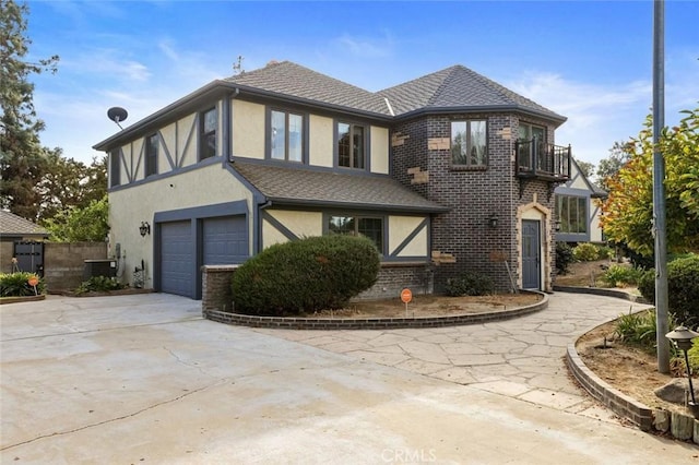 view of front of property with a garage, a balcony, and central air condition unit