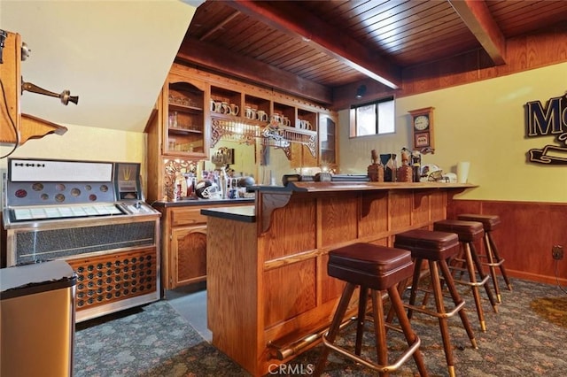 bar with beam ceiling, wood walls, and wood ceiling