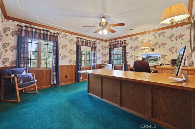 office area with dark carpet, ceiling fan, ornamental molding, and wood walls