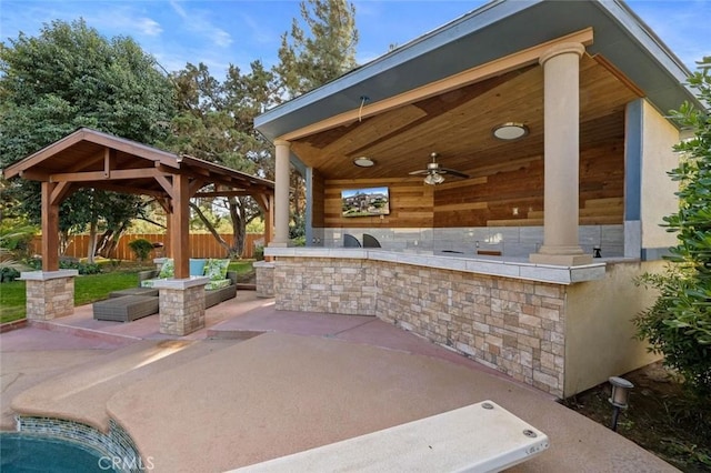 view of patio with a gazebo, a bar, and ceiling fan