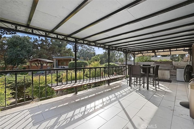 view of patio / terrace featuring an outdoor kitchen and exterior bar